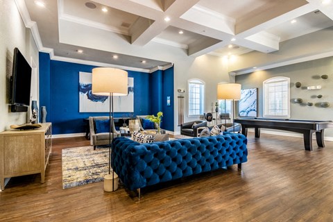 a living room with a blue couch and a pool table